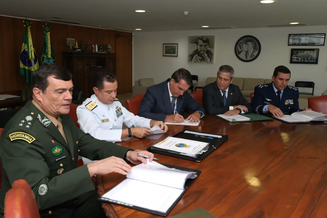 Jair Bolsonaro sentado à mesa com autoridades militares durante audiência no Planalto em março de 2022.